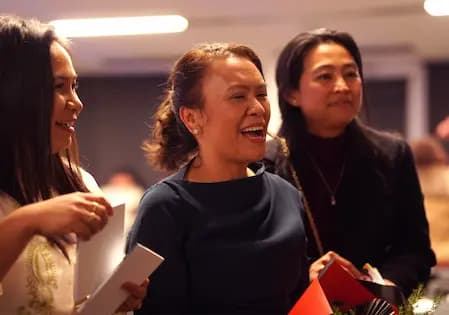 three people smiling at an OrbitRemit event