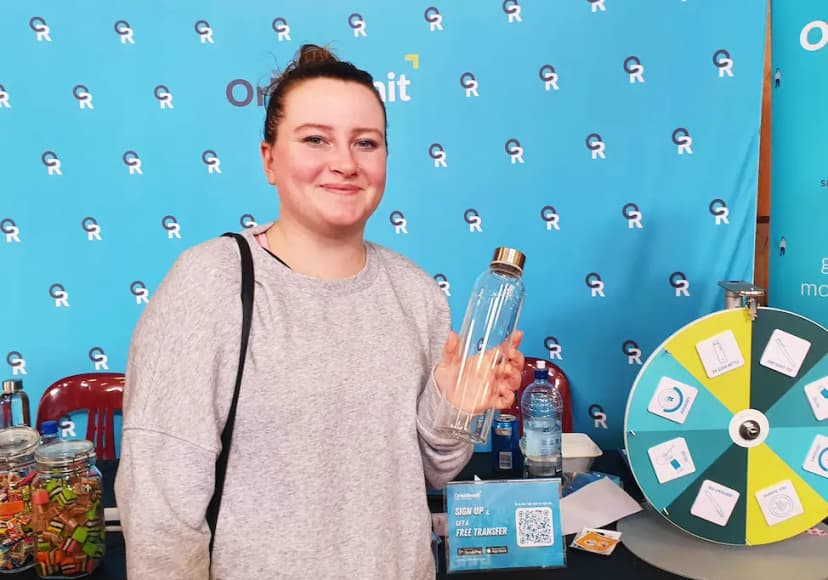 women at an OrbitRemit event holding a drink bottle